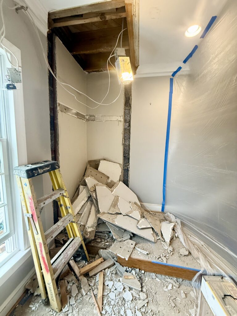 photo showing demolished closet space inside plastic protective walls to contain dust