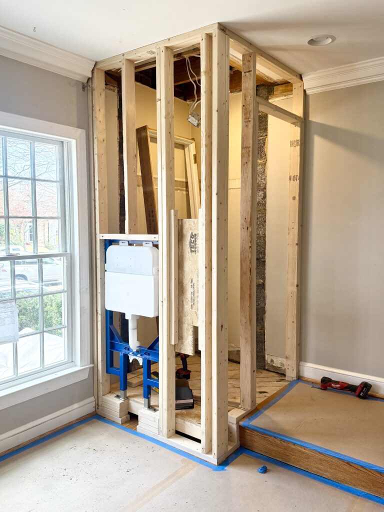 photo showing framing and rough plumbing for new row house powder room