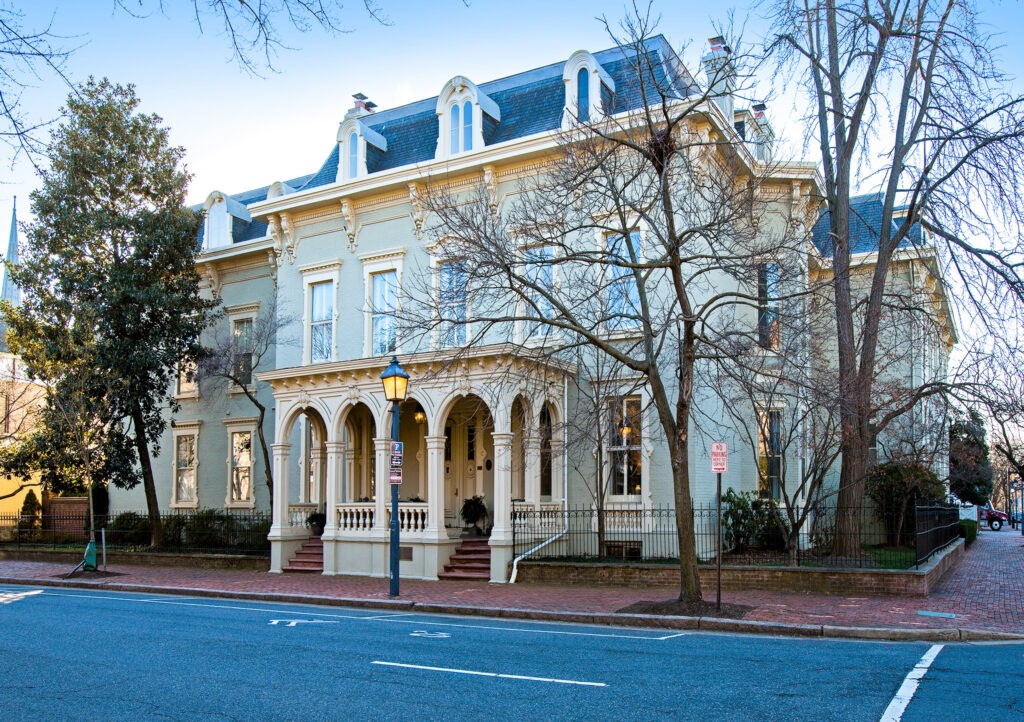 The Swann-Daingerfield House in Old Town Alexandria, a large historic home with a mansard roof, ornate brackets, and arched porch openings