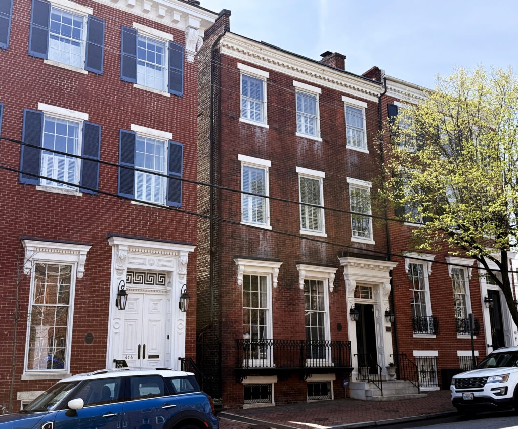 Historic brick Federal-style row houses in Old Town Alexandria with tall windows, symmetrical façades, and decorative entry surrounds