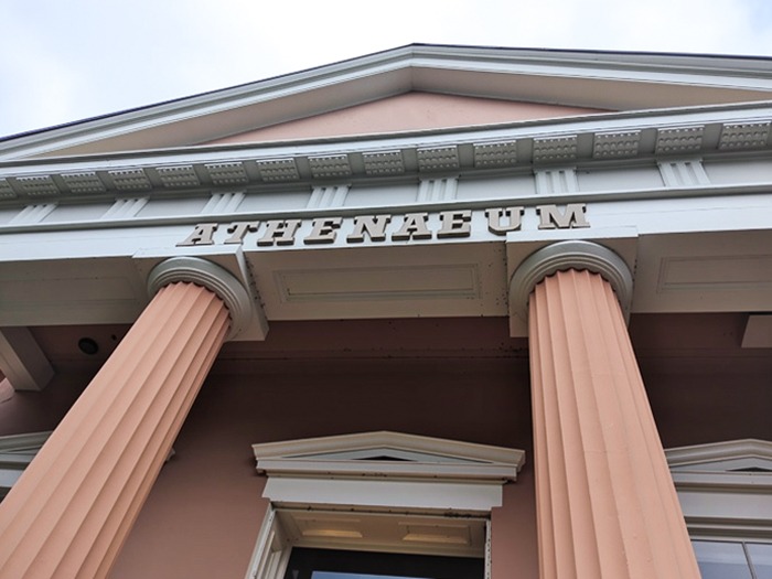 Front façade of The Athenaeum in Old Town Alexandria, featuring classical columns and Greek Revival detailing